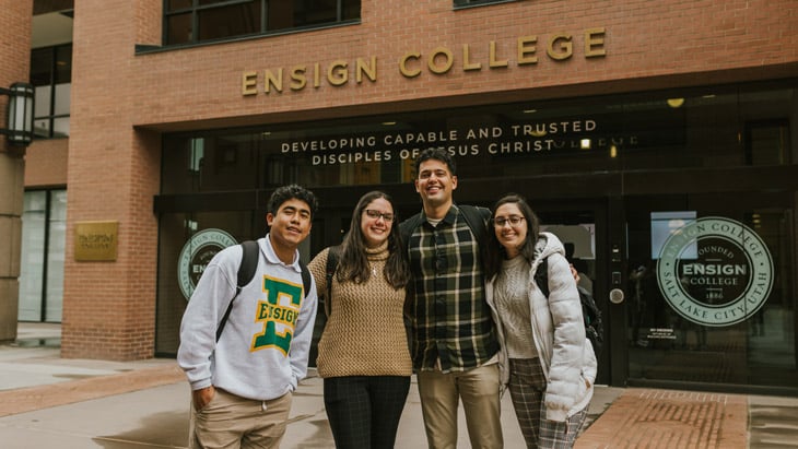 Four Ensign College students in front of the Ensign College building