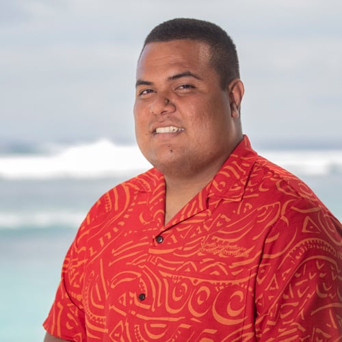 Temwake wearing a red shirt in front of the ocean