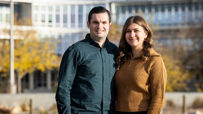 Man and woman with BYU buildings and mountains in background.