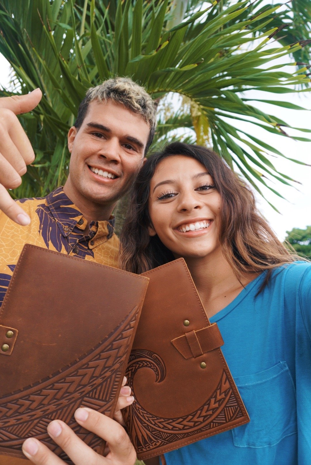 Young man and young woman holding leather journals