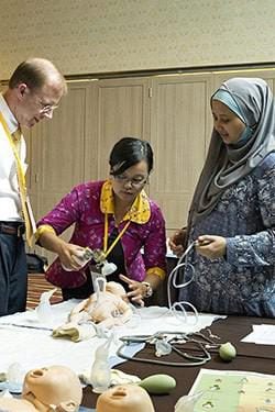 Dr. Michael Visick oversees an individual practical examination of skills learned by midwives.