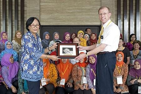 Dr. Visick presents a gift to Dr. Eriyati in front of 600 midwives