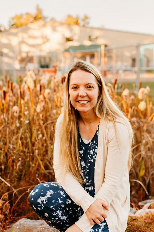 Female student in front of bullrushes.