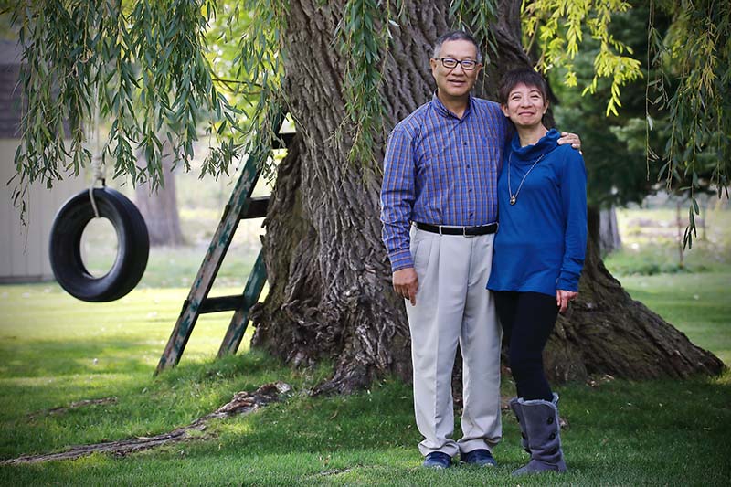 Knight Society members Ray and Yukiko Matsuura in front of a large tree with a tire swing and ladder.