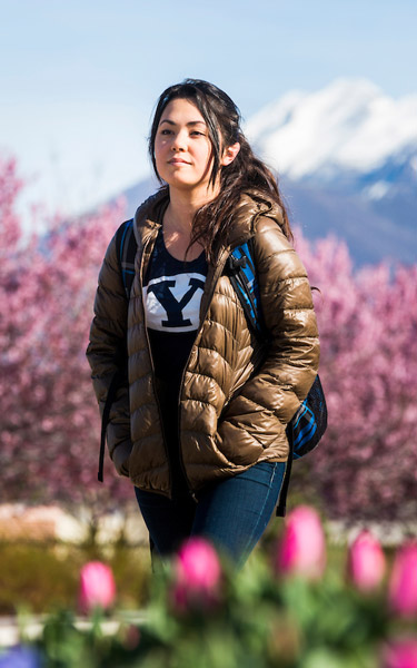 female student walking outdoors in the spring time
