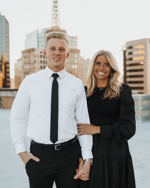 Corinne Case and her husband pose for a photo outdoors on a rooftop