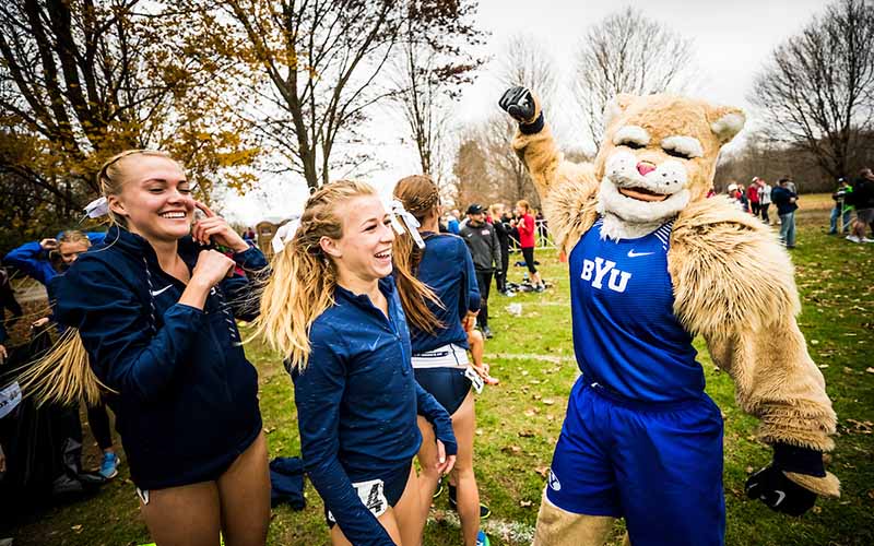 Cosmo celebrates with BYU Women’s Cross Country team members.