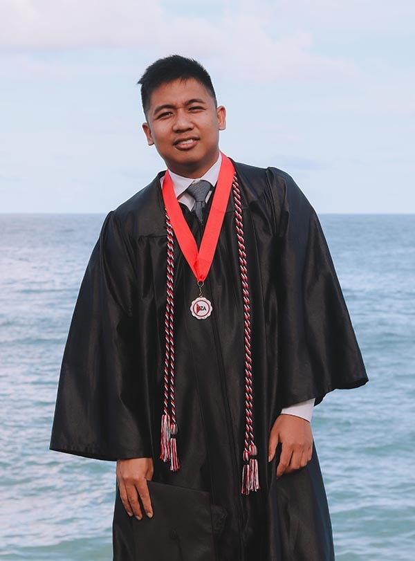 Filipino man wearing graduation gown