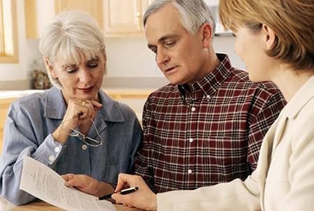 A couple reviewing a document with their professional advisor.