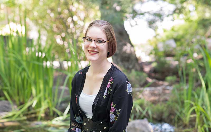 A photo of Ashlyn Brinkman sitting in BYU-Idaho’s Ricks Gardens.