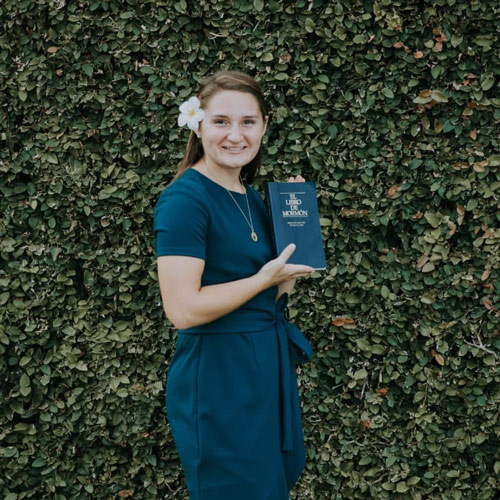 Elle Larson posing with a Spanish Book of Mormon