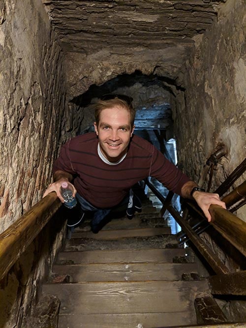 Young man climbing stairs in a tunnel during a study abroad assignment.