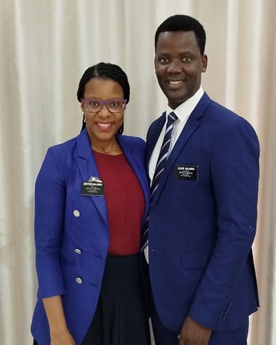 An African man and woman wearing name tags identifying them as missionaries.