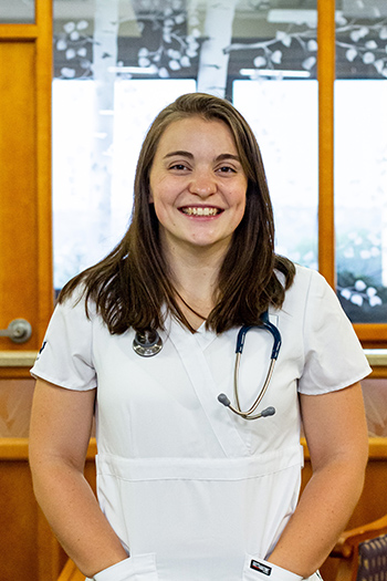 Student in nursing scrubs with stethoscope.