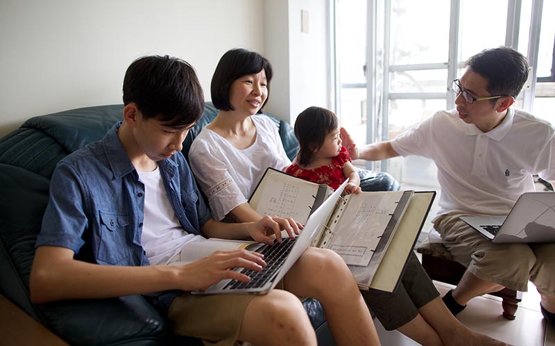 family sitting on couch looking at family history records
