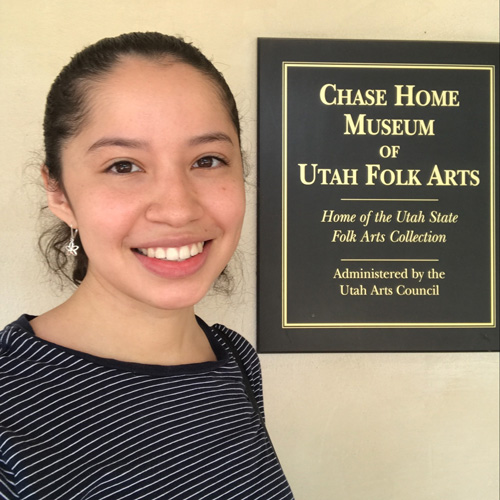 Natalie Escalante next to the Chase Home Museum of Utah Folk Arts plaque.