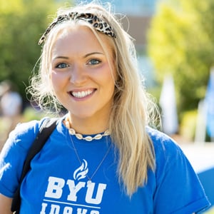 Blonde female BYU-Idaho student outside on campus wearing a blue BYU-Idaho spirit t-shirt