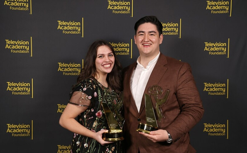 Two BYU students accepting emmy awards on stage