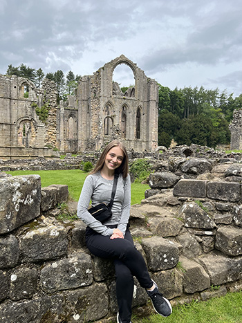 Female college student in front of Fountains Abbey