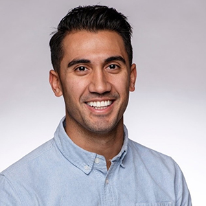 Portrait of a smiling BYU student wearing a blue button-down dress shirt.