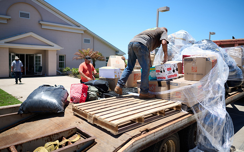 man on truck bed moving supplies to people in Maui.